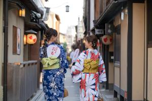 two women in kimonos walking down a street at OMO5 Kyoto Sanjo by Hoshino Resorts in Kyoto