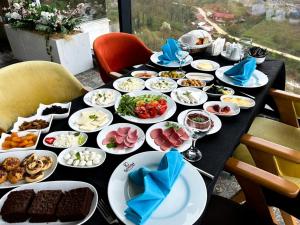 una mesa negra con platos de comida. en KANYON VADİ HOTEL, en Bostanbükü