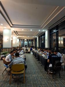 un grupo de personas sentadas en mesas en una habitación en KANYON VADİ HOTEL, en Bostanbükü