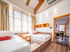 a hotel room with two beds and a mirror at Xi'an Simple Palace in Xi'an