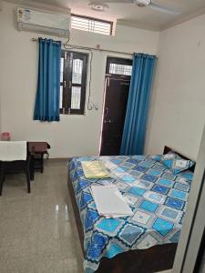 a bedroom with a bed with a laptop on it at Hari Kripa Sadan in Ayodhya