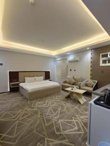 um quarto com uma cama, um sofá e uma mesa em Maro Hotel em Abha