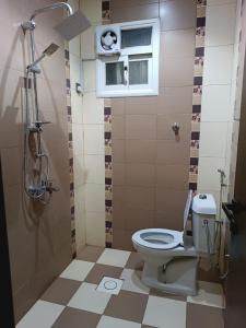 uma casa de banho com um WC, uma janela e um chuveiro em Maro Hotel em Abha