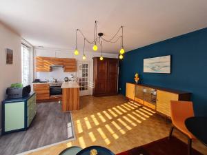 une cuisine aux murs bleus et une cuisine avec une table dans l'établissement Gîte Nancy, 2 pièces, 2 personnes - FR-1-584-316, à Nancy