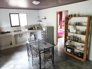 a kitchen with a table and chairs and a refrigerator at Casa el Colibrí in Naranjo