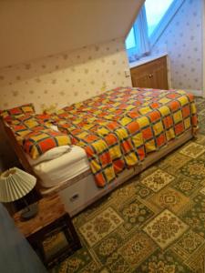 a bedroom with a bed with a colorful comforter at Winston House in Bridlington