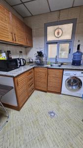 a kitchen with a sink and a washing machine at Paradiso Backpackers Nest 1 in Abu Dhabi