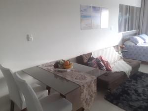 a living room with a table and a couch at Loft Praia de Armação in Salvador