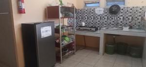 a kitchen with a counter and a refrigerator in it at Graha Aditya Syariah in Palembang