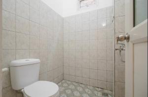 uma casa de banho com um WC e um chuveiro em Graha Aditya Syariah em Palimbão