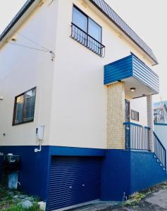ein weißes und blaues Haus mit einer blauen Garage in der Unterkunft Kotoni / Vacation STAY 4930 in Sapporo