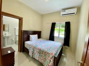 una camera con letto e un bagno con finestra di Elegante Apartamento A 100 mts la playa de los Minos RSJ a Río San Juan