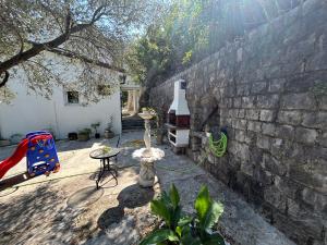 patio z ceglaną ścianą, stołem i krzesłem w obiekcie Vila Violeta w mieście Donji Morinj