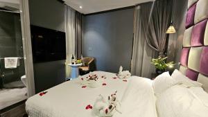 1 dormitorio con 2 conejos en una cama con flores en Hanoi La Storia Hotel, en Hanói