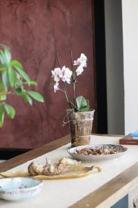 una mesa con un jarrón de flores y un plato de comida en Solar de Santa Maria, en Bragança