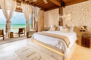 a bedroom with a bed and a view of the ocean at AWA Holbox Hotel Boutique - Beach Front in Holbox Island