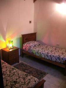 1 dormitorio con 2 camas y vestidor con lámpara en Cabañas San Nicolas en Carpintería