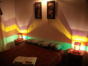 1 dormitorio con 1 cama y 2 luces en la pared en Cabañas San Nicolas en Carpintería