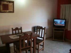 comedor con mesa y TV en Cabañas San Nicolas en Carpintería
