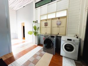 a laundry room with a washer and dryer in it at Woodenhousevilla suratthani-วิลล่าบ้านไม้สุราษฎร์ in Ban Kadae Chae