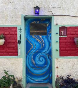 una puerta pintada como una ola con una luz en la parte superior en Puerta Azul en Capilla del Monte