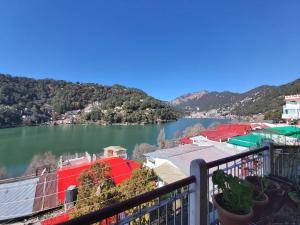 vistas a un lago con montañas en el fondo en Goroomgo Lake View Mall Road Nainital - Mountain View & Spacious Room, en Nainital