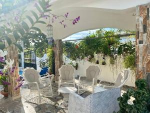 - un ensemble de chaises blanches sur la terrasse dans l'établissement Casa Tipo Villa, Piscina, Playas De RSJ a 4 min, à Río San Juan