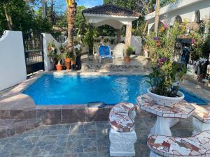 - une piscine dans une cour avec des chaises et un parasol dans l'établissement Casa Tipo Villa, Piscina, Playas De RSJ a 4 min, à Río San Juan