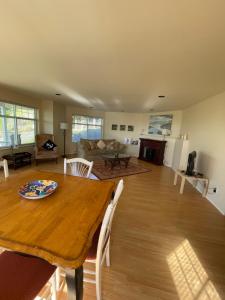 a living room with a wooden table and a living room at Skyview Apartment at Otter Point in Sooke