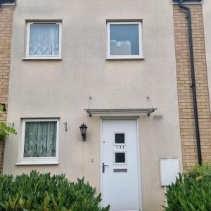 a building with a white door and two windows at 3 bed house - Milton Keynes - Countess Plaza in Broughton