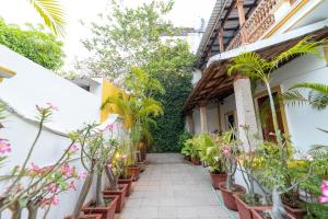 a courtyard of a house with potted plants at Dumas Guest House in Puducherry