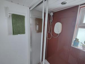 a shower with a glass door in a bathroom at Tiny float home Brighton in Brighton & Hove