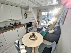 a small living room with a table and a kitchen at Tiny float home Brighton in Brighton & Hove