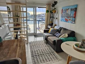 a living room with a couch and a table at Tiny float home Brighton in Brighton & Hove
