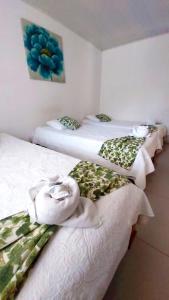 2 Betten mit Handtüchern auf einem Zimmer in der Unterkunft Hotel Golfito in Golfito