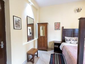 1 dormitorio con cama y espejo en Cloudwalks Homestay en Kodaikānāl