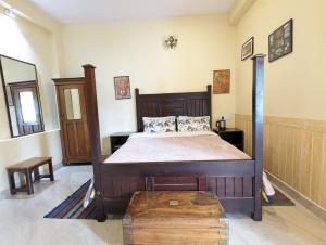 1 dormitorio con 1 cama con marco de madera en Cloudwalks Homestay en Kodaikānāl