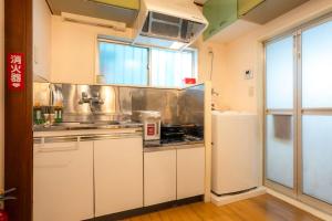 a kitchen with white cabinets and a sink at 五十岚民宿 地铁站步行4分 免费高速 WI-FI TraditionCozy Japanese Villa in Ikebukuro 6mins St with Hight speed WIFI in Tokyo