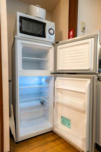 an open refrigerator with a microwave on top of it at 五十岚民宿 地铁站步行4分 免费高速 WI-FI TraditionCozy Japanese Villa in Ikebukuro 6mins St with Hight speed WIFI in Tokyo