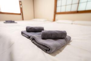 two towels are sitting on top of a bed at 五十岚民宿 地铁站步行4分 免费高速 WI-FI TraditionCozy Japanese Villa in Ikebukuro 6mins St with Hight speed WIFI in Tokyo