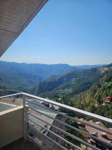 a view of the mountains from a balcony of a house at Cozy Cove - Newly built 3BHK Duplex with rare valley view in Shimla