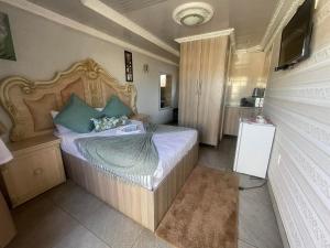 ein kleines Schlafzimmer mit einem Bett mit blauen Kissen in der Unterkunft Kea-Resort in Hammanskraal next to Dinokeng Game Reserve in  Hammanskraal 