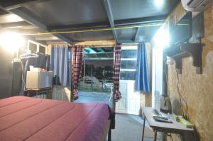 a bedroom with a bed and a tv and a balcony at ayutthaya river camp and yacht charter 