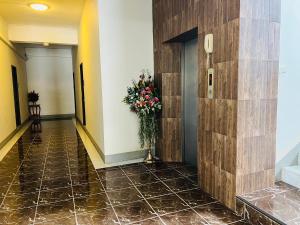 a hallway of a hotel with a vase of flowers at Pilatus Apartment in Loei