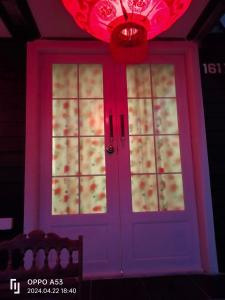 una puerta morada con una lámpara de araña y una luz roja en บ้านระเบียงน้ำวังใหญ่ วังสามหมอ อุดร, en Wang Sam Mo
