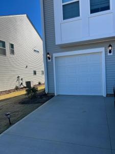 a house with a white garage door next to a house at Nurse's Nest LLC in Spartanburg