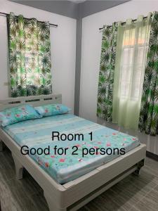 een slaapkamer met een bed met de woorden kamer goed voor personen bij Romblon Transient House 2nd Floor in Romblon