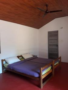 a bedroom with a bed with a ceiling fan at Tranquilandia in Varagampadi