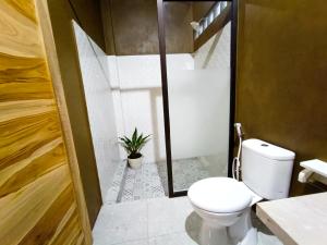 ein Badezimmer mit einem WC und einer Pflanze darin in der Unterkunft Artomoro Bali in Munduk