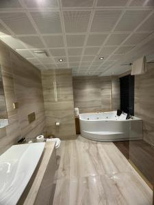 een grote badkamer met 2 wastafels, een bad en een bad bij Amorium Hotel in Kastamonu